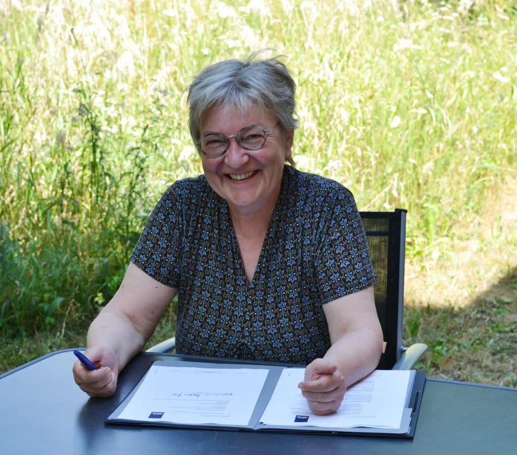 Kirchenpräsidentin Dorothee Wüst unterschreibt den Partnerschaftsvertrag